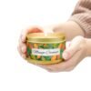 mango coconut 8 oz gold tin candle jar lit with hands holding jar