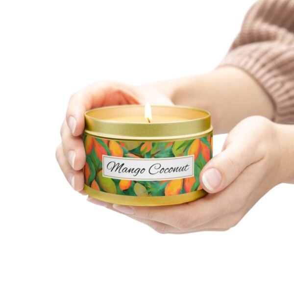 mango coconut 8 oz gold tin candle jar lit with hands holding jar