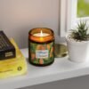 mango coconut lit candle amber jar on shelf