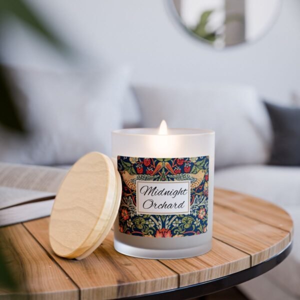 Midnight Orchard wood wick lit candle sitting on wood table