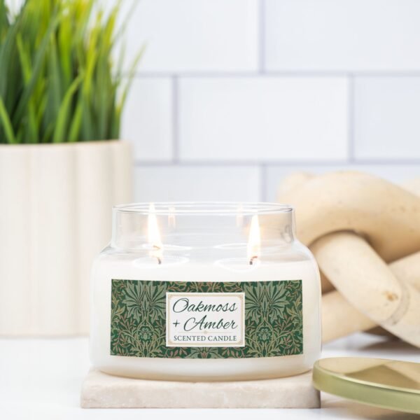 Oakmoss Amber candle in a lit double wick apothecary jar on counter Oakmoss Amber candle in a lit double wick apothecary jar on counter