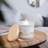 Ocean Breeze wood wick lit candle sitting on table